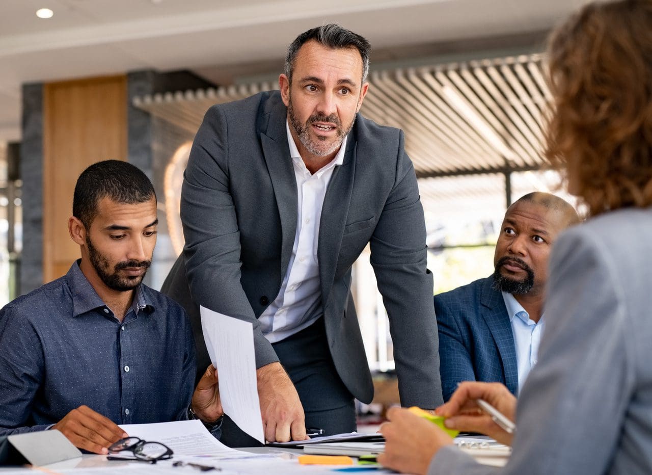 Manager leading team discussion around conference table