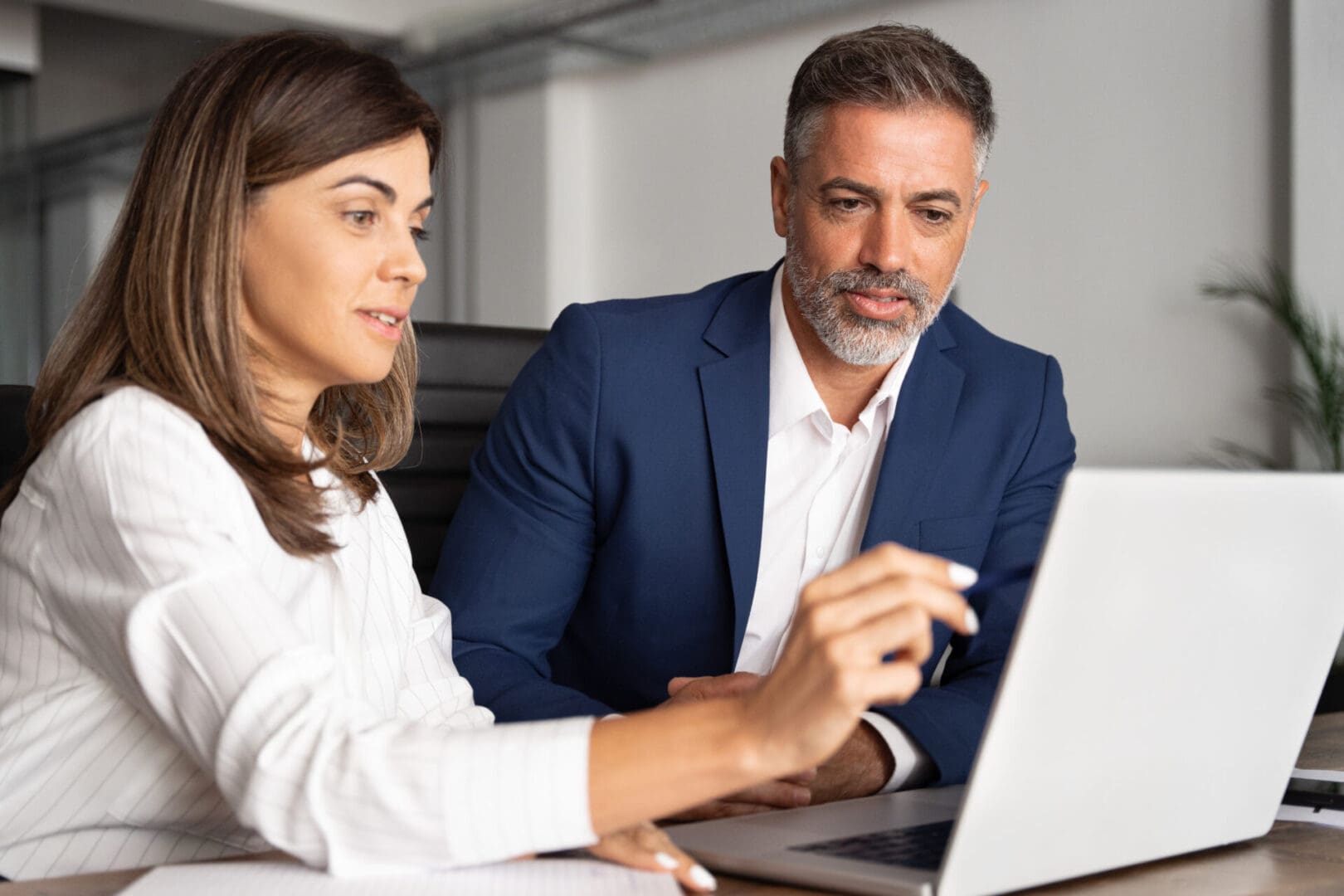Business colleagues collaborating over laptop